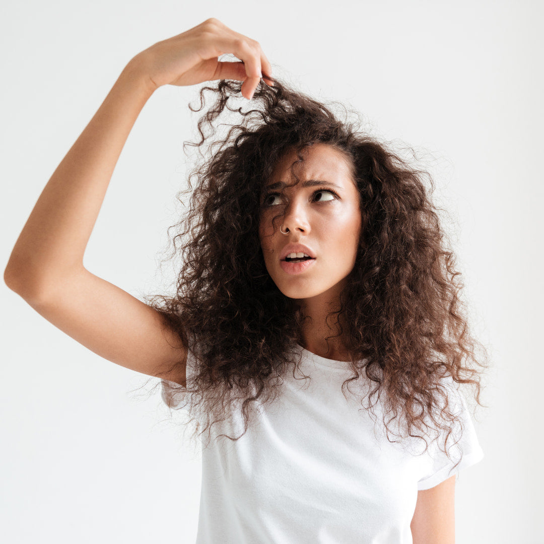 Femme qui regarde ses cheveux - Djohannie Beauty