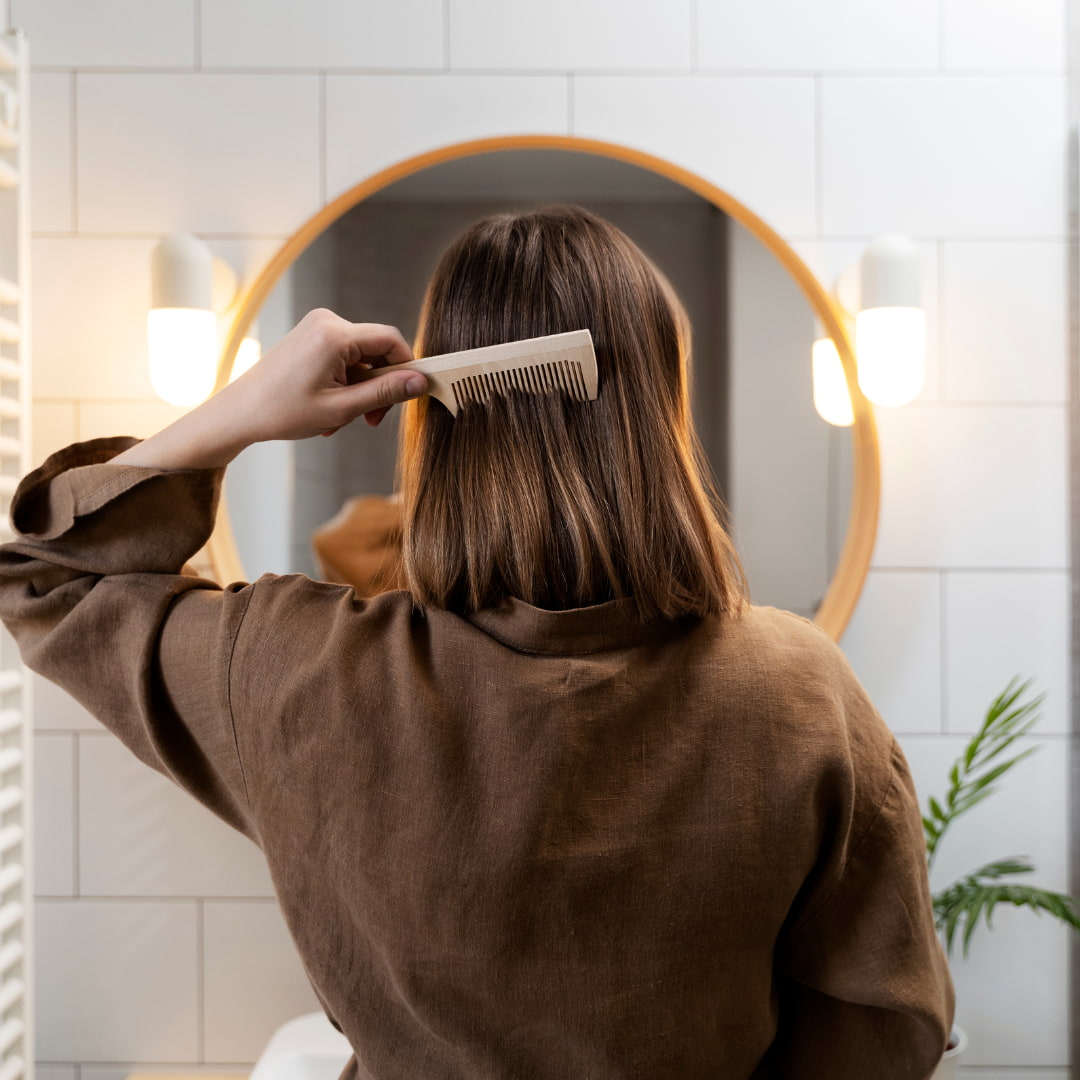 Femme qui se brosse les cheveux