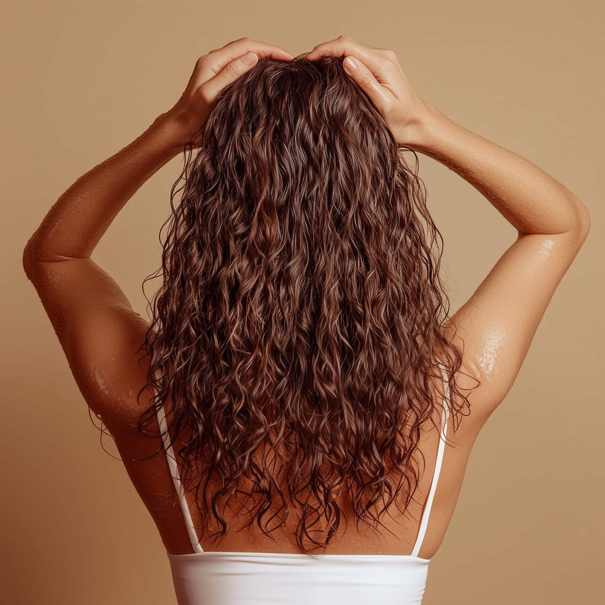 Photographie d'une femme de dos qui touche ses cheveux