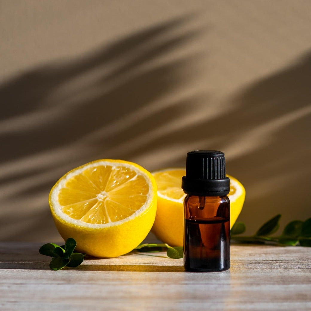 Huiles essentiels sur un fond beige avec un citron